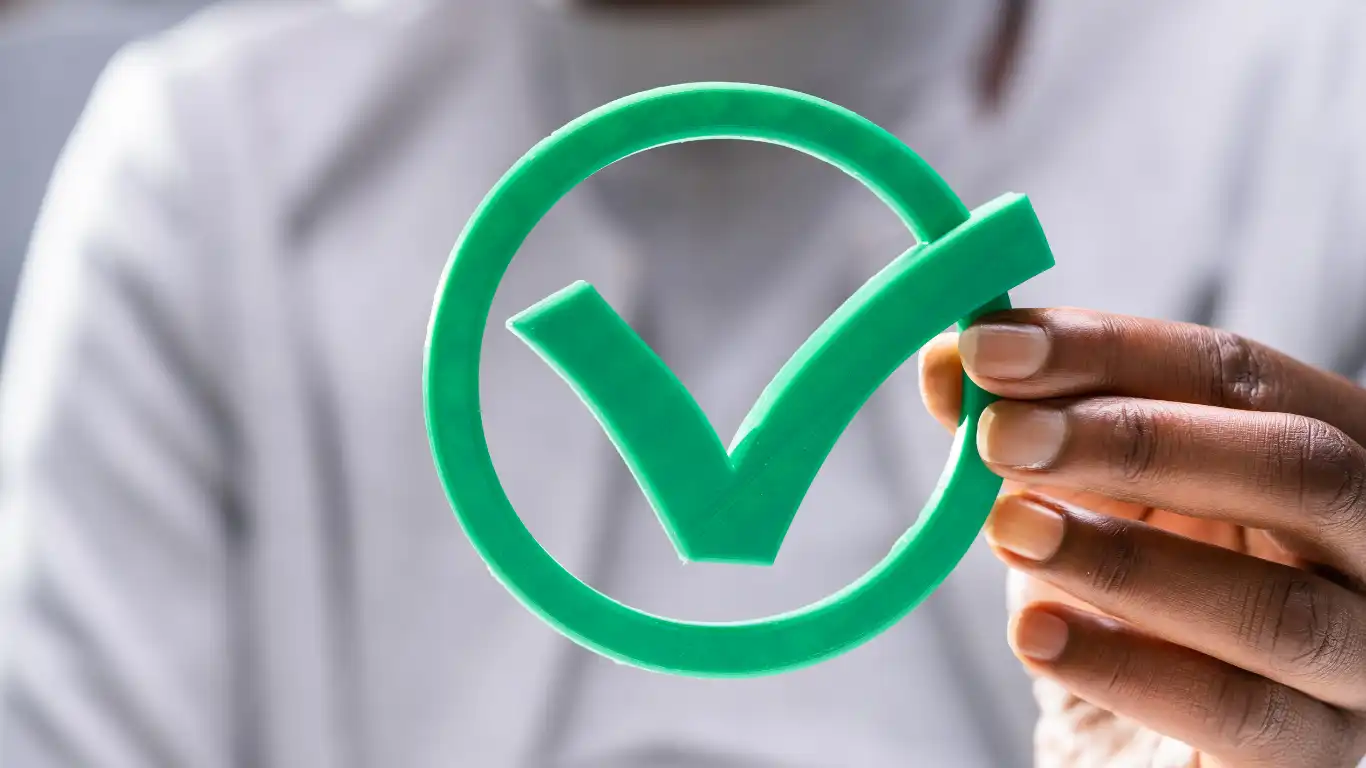 チェックマークの模型を持っている