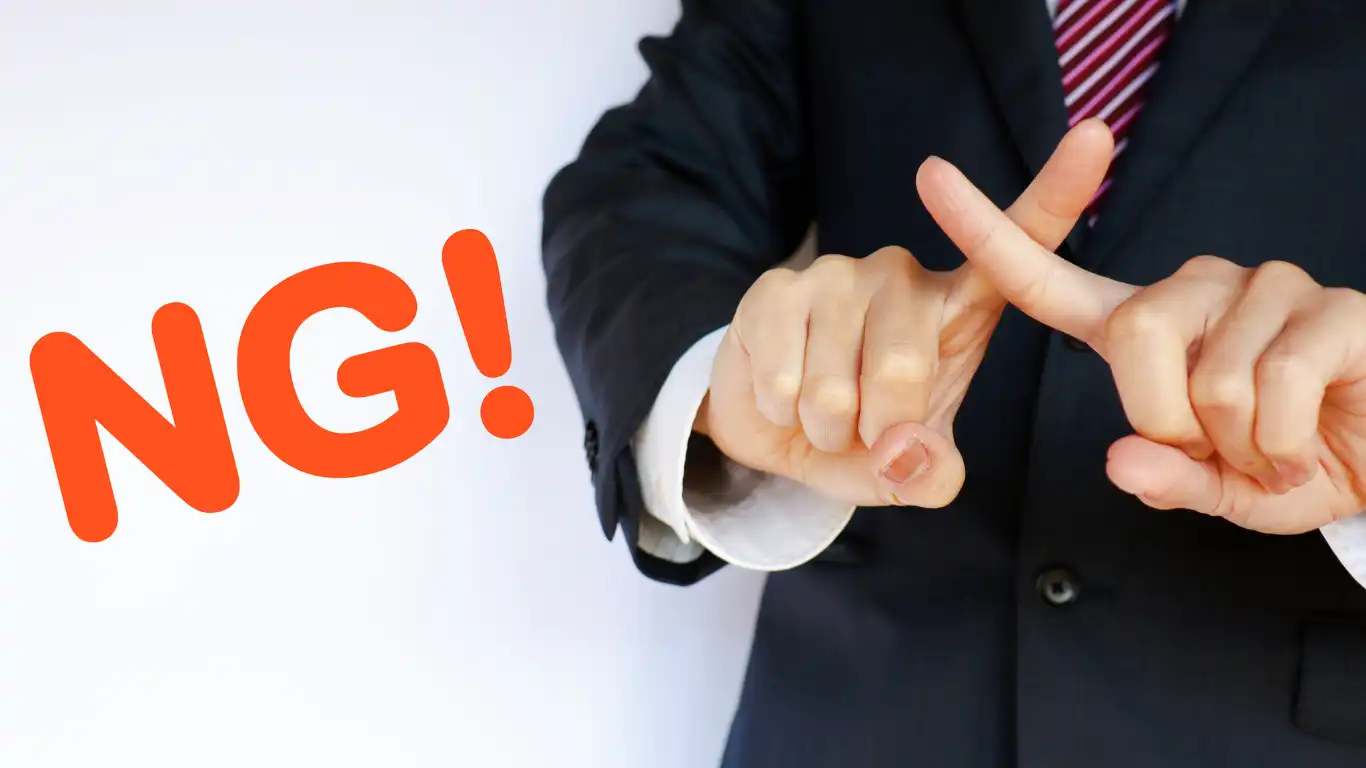 男性が指でバツ印をしている