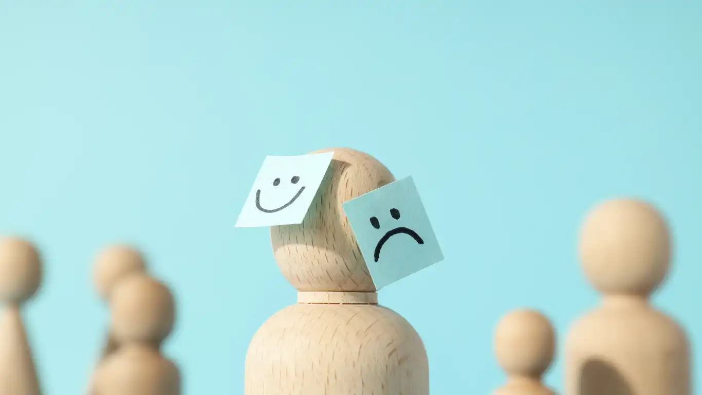 木の人形に表情が書かれた紙が貼られている