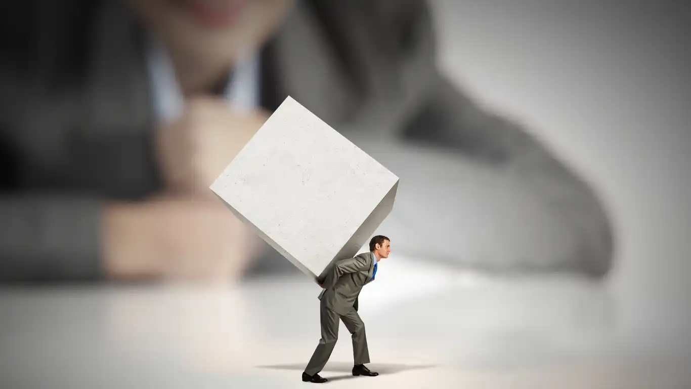 大きな荷物を背負っている男性の模型を見つめる