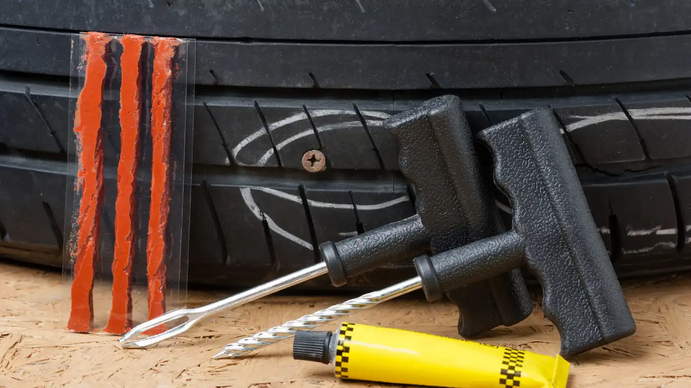 ネジが刺さってパンクしたタイヤの前に修理キットを置いている