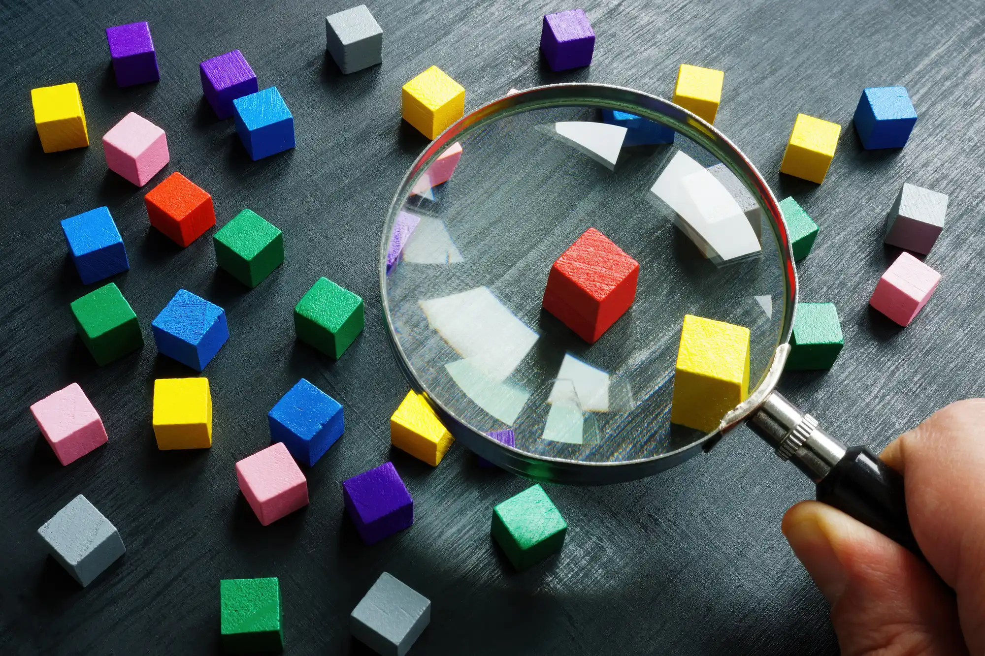 虫眼鏡で小さな色付きキューブを観察